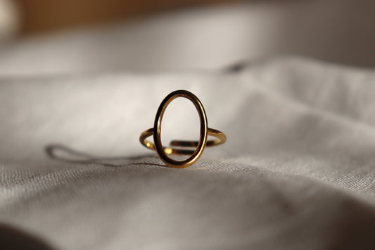 Anello Empty Gold regolabile minimalista in oro su sfondo grigio