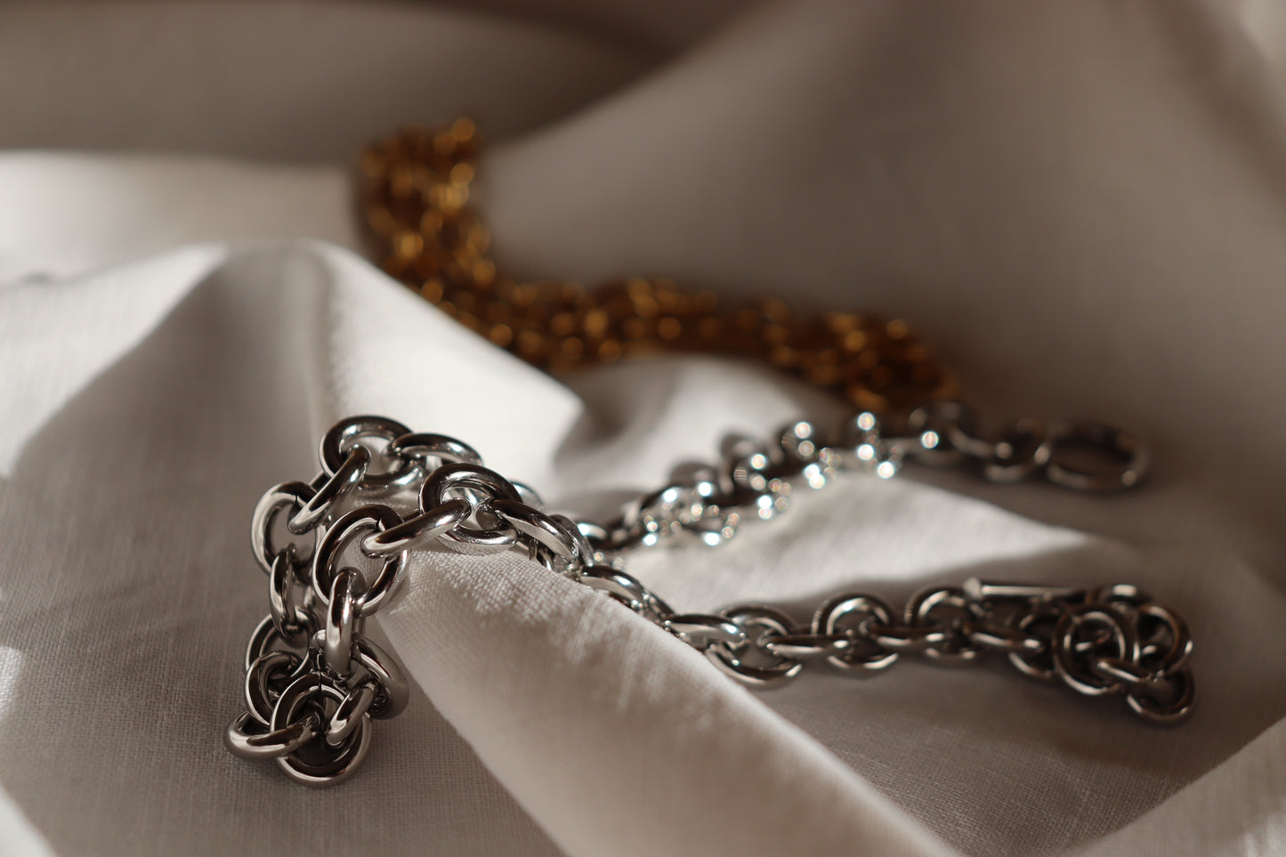 Collana Imperial in oro o argento elegante con chiusura a T su sfondo bianco
