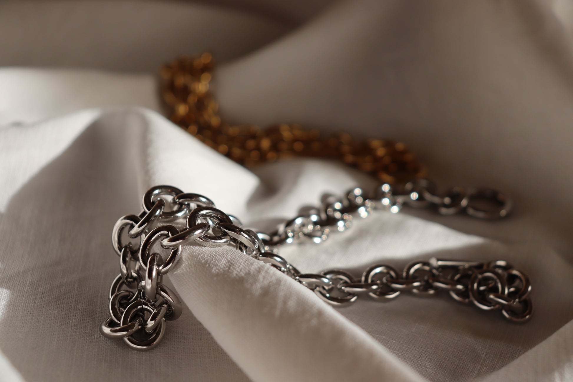 Collana Imperial in oro o argento elegante con chiusura a T su sfondo bianco
