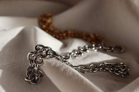 Collana Imperial in oro o argento elegante con chiusura a T su sfondo bianco
