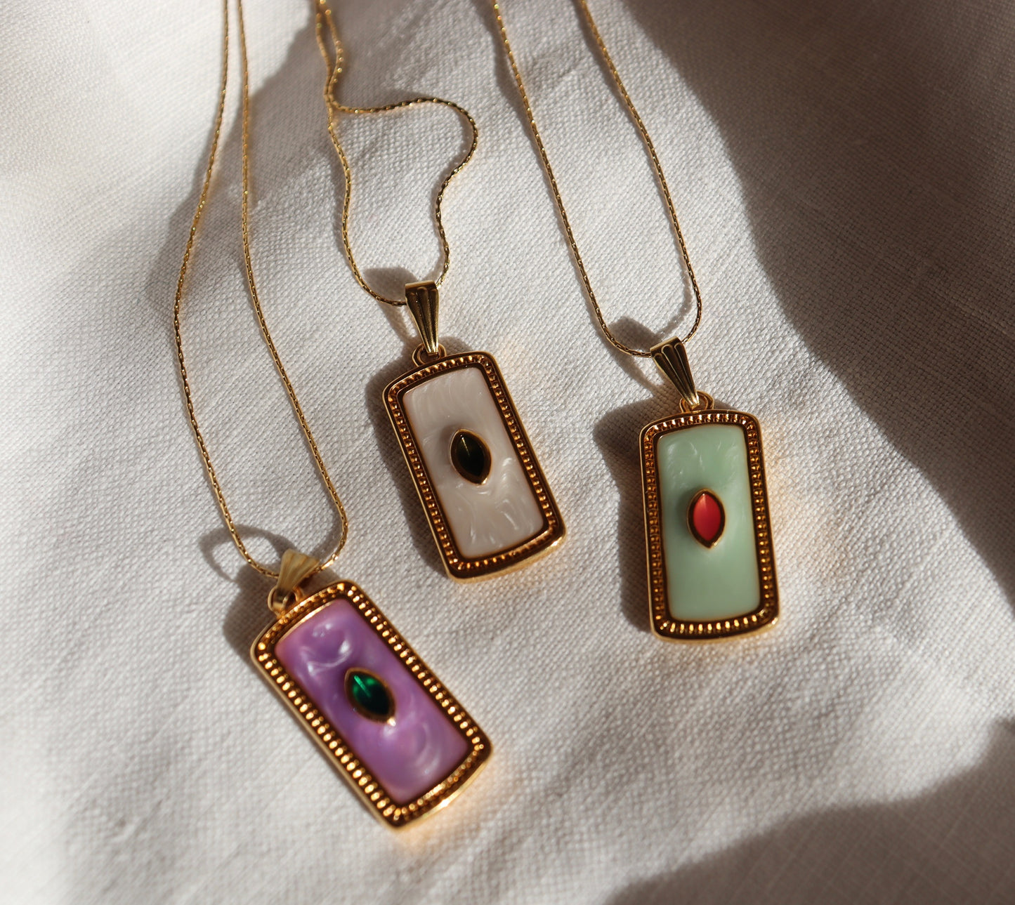 Collana Seed in oro con ciondolo a forma di seme su sfondo bianco
